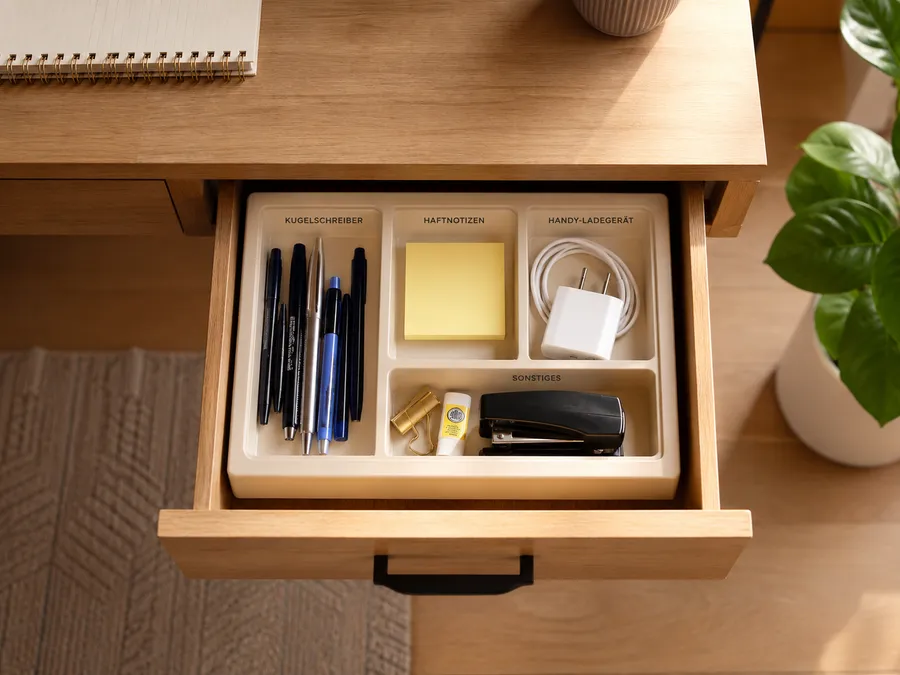 Geöffnete Schreibtischschublade mit Organizer-Einsatz für Stifte, Klebezettel und Ladekabel im Homeoffice