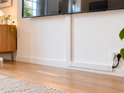 Kabelsalat hinter dem Fernseher vor dem Aufräumen, mehrere unterschiedlich lange schwarze Kabel führen vom TV zur Steckdose, typischer Ausgangspunkt für Kabelmanagement im Wohnzimmer